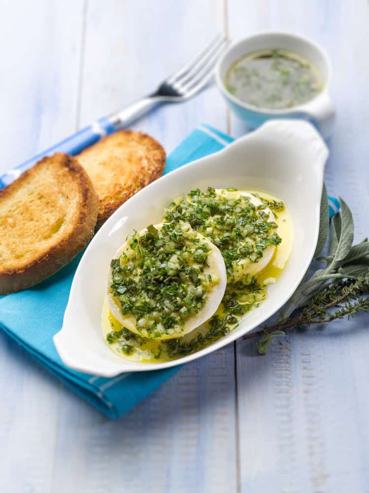Tomini con salsa verde e sfondo di fette di pane tostato, prodotto tipico della cucina piemontese