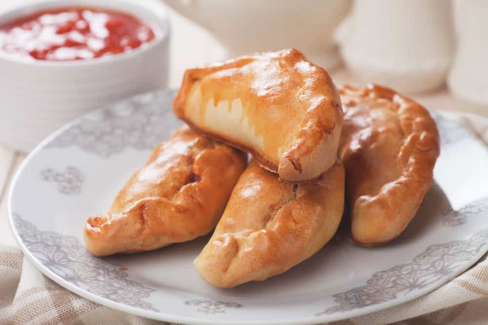 Casciatelli molisani dorati serviti su piatto elegante, panzerotti salati ripieni di caciotta e uova tipici della cucina molisana.