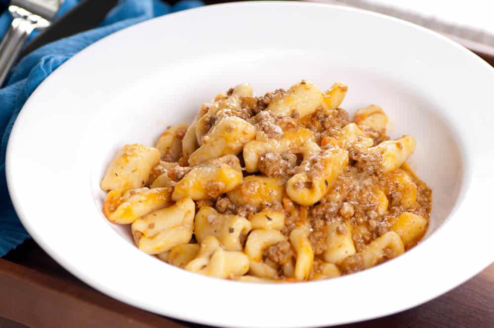 Cavatelli al sugo di carne serviti in un piatto bianco, con ragù di maiale e formaggio grattugiato, ricetta tipica molisana.