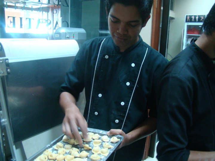 Allievo che prepara pasta fresca durante una lezione di cucina