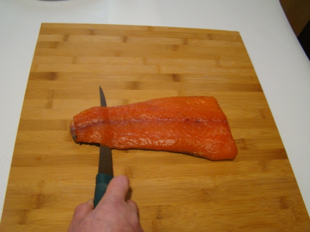 Taglio della pelle dal filetto di salmone dopo la marinatura a secco