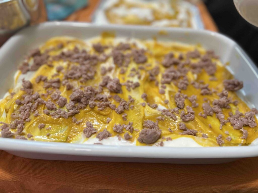 Lasagne nella fase di composizione con crema di zucca e besciamella.