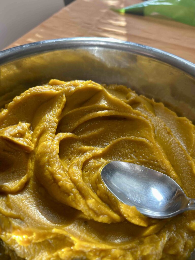 Crema di zucca vellutata in una ciotola con cucchiaio.