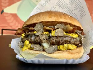 Hamburger al tartufo con ovetto strapazzato, guanciale croccante e carne di manzo gourmet
