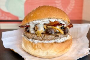 Hamburger gourmet ai funghi con porcini, pioppini e finferli, taleggio fuso, guanciale croccante e salsa ai funghi artigianale