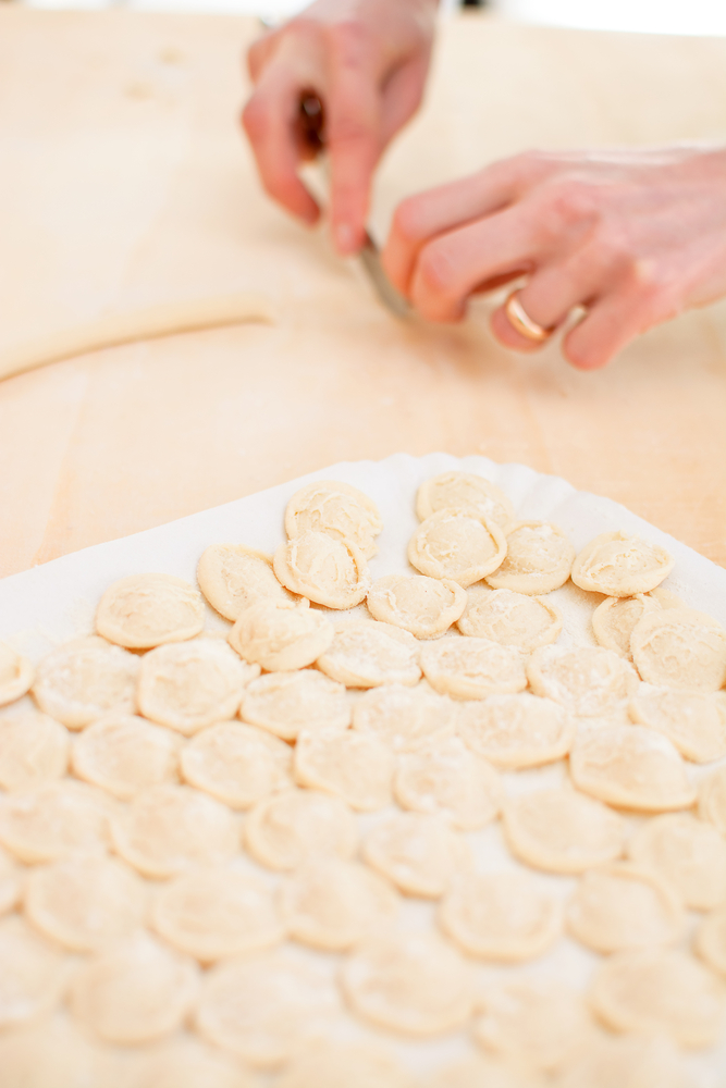 Orecchiette fresche appena formate e disposte su vassoio infarinato per l’asciugatura.