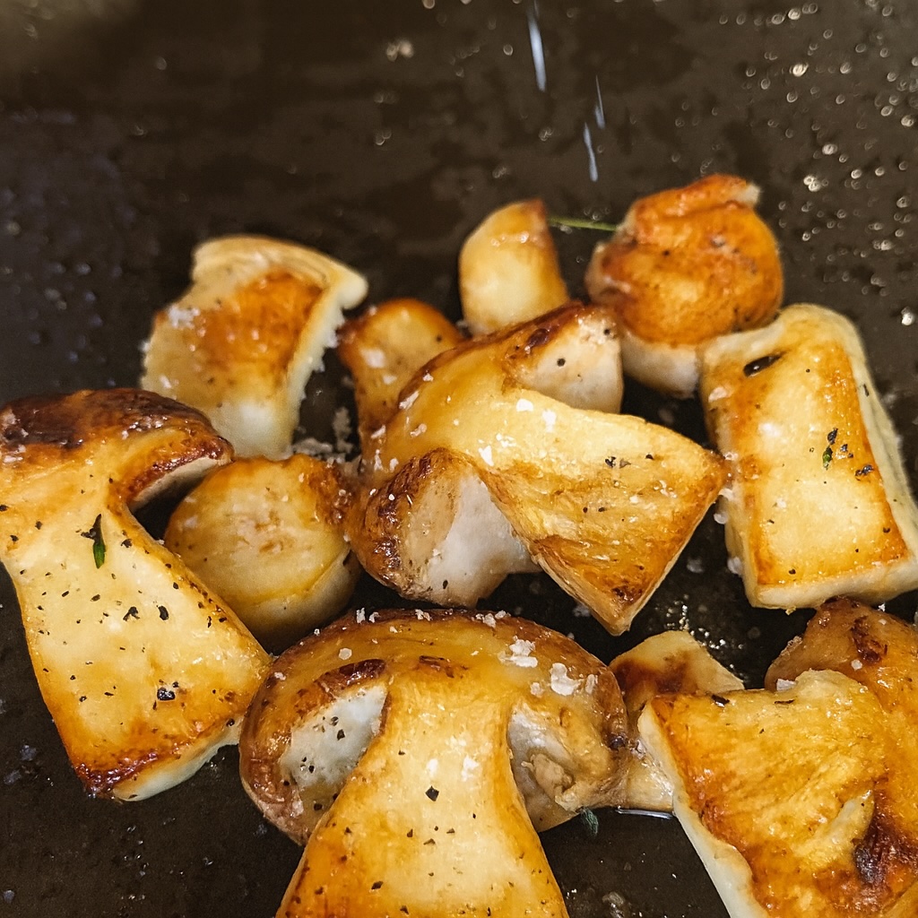 Porcini scottati in padella fino a doratura, con sale e pepe, pronti per l’impiattamento del tuorlo croccante.