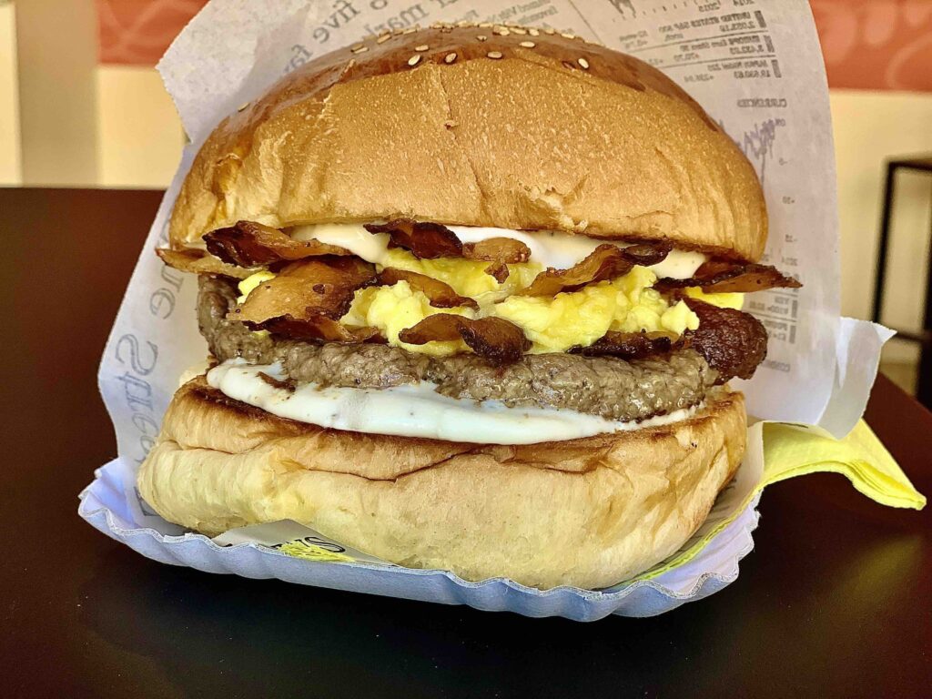 Carbonara Burger con svizzera di manzo, guanciale croccante, tuorlo cremoso e crema di pecorino al pepe nero